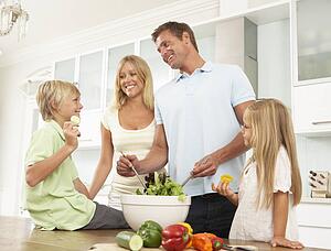 Father & Son Preparing Salad In Modern Kitchen