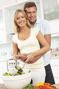 Couple Preparing Salad In Modern Kitchen