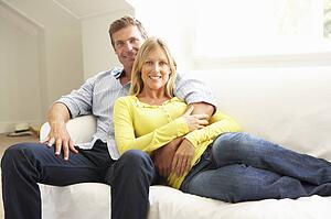 Couple Relaxing On Sofa At Home