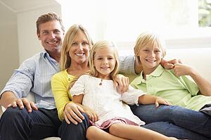 Portrait Of Young Family Relaxing Together On Sofa