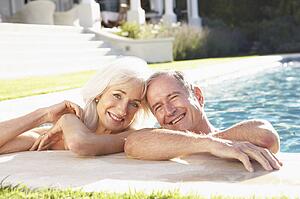 Senior Couple Relaxing by Outdoor Pool