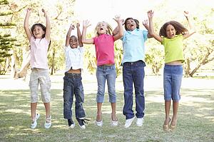 Group Of Children Jumping In Air In Park