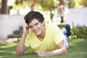 Portrait Of Teenage Boy Laying In Park