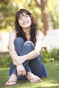 Portrait Of Teenage Girl Sitting In Park