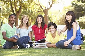 Group Of Teenage Students Chatting Together In Park