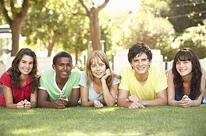 Group Of Teenagers Lying On Stomachs In Park