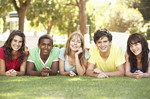 Group Of Teenagers Lying On Stomachs In Park