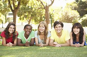 Group Of Teenagers Lying On Stomachs In Park