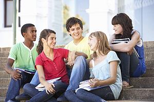 Group Of Teenage Friends Sitting On College Steps Outside
