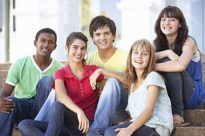 Group Of Teenage Friends Sitting On College Steps Outside
