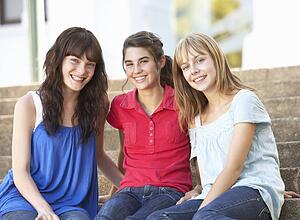 Group Of Teenage Female Friends Sitting On College Steps Outside