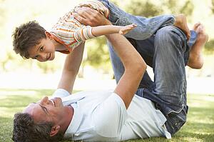 Father And Son Playing Together In Park