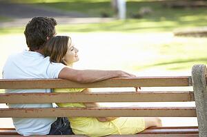 Couple Sitting Together On Park Bench