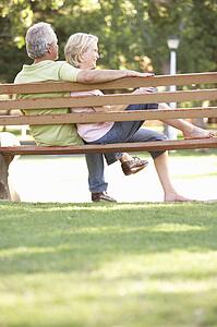Senior Couple Sitting Together On Park Bench