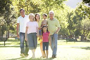Extended Group Portrait Of Family Enjoying Walk In Park