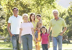 Extended Group Portrait Of Family Enjoying Walk In Park