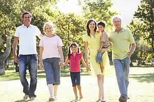 Extended Group Portrait Of Family Enjoying Walk In Park