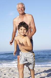 Grandfather, Father and Grandson Running Along Beach