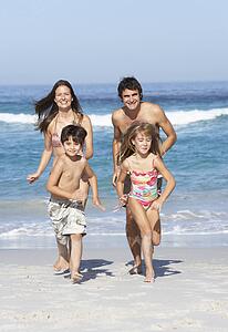 Young Family Running Along Beach on Holiday