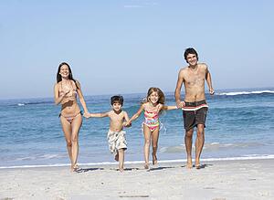 Young Family Running Along Beach on Holiday