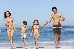 Young Family Running Along Beach on Holiday
