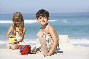 Children Building Sandcastles On Beach Holiday