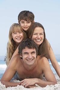 Young Family Having Fun On Beach Holiday
