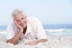 Senior Man Relaxing On Sandy Beach