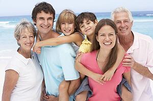 Three Generation Family Relaxing On Beach Holiday