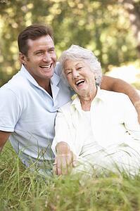 Senior Woman With Adult Son In Garden