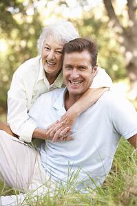 Senior Woman With Adult Son In Garden