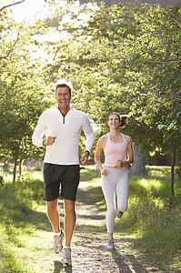 Middle Aged Couple Jogging In Park