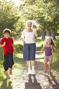 Grandmother Jogging In Park With Grandchildren