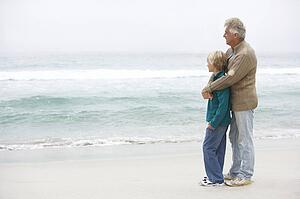 Grandfather And Son Standing On Winter Beach Together