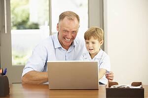 Father And Son Using Laptop At Home