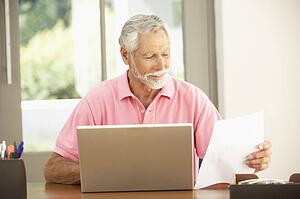Senior Man Using Laptop At Home