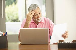 Senior Man Using Laptop At Home