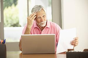 Senior Man Using Laptop At Home