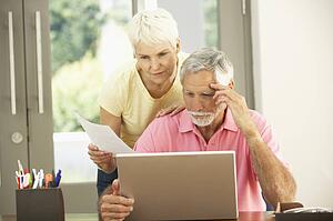 Worried Senior Couple Using Laptop At Home