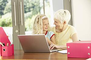 Granddaughter And Grandmother Using Laptop At Home
