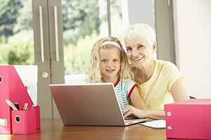 Granddaughter And Grandmother Using Laptop At Home