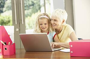 Granddaughter And Grandmother Using Laptop At Home