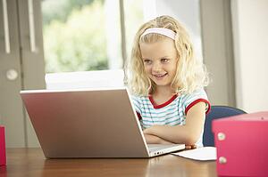 Young Girl Using Laptop At Home