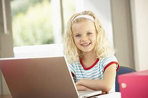 Young Girl Using Laptop At Home