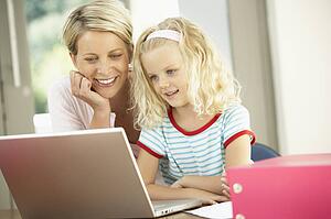 Mother And Daughter Using Laptop At Home