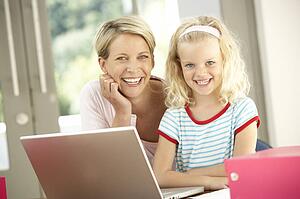 Mother And Daughter Using Laptop At Home