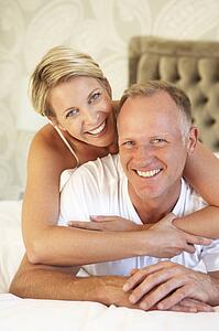 Couple Relaxing In Bedroom