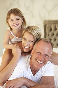 Family Relaxing In Bedroom