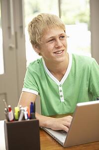 Teenage Boy Using Laptop At Home