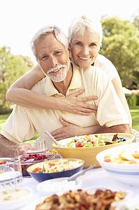 Senior Couple Enjoying Meal In Garden